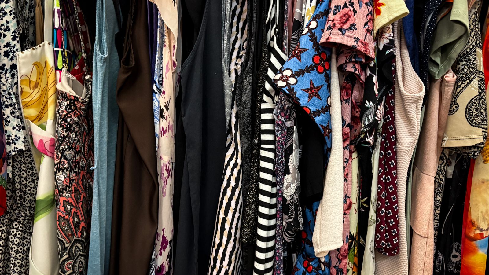 A vibrant rack of assorted vintage clothes in many patterns and styles