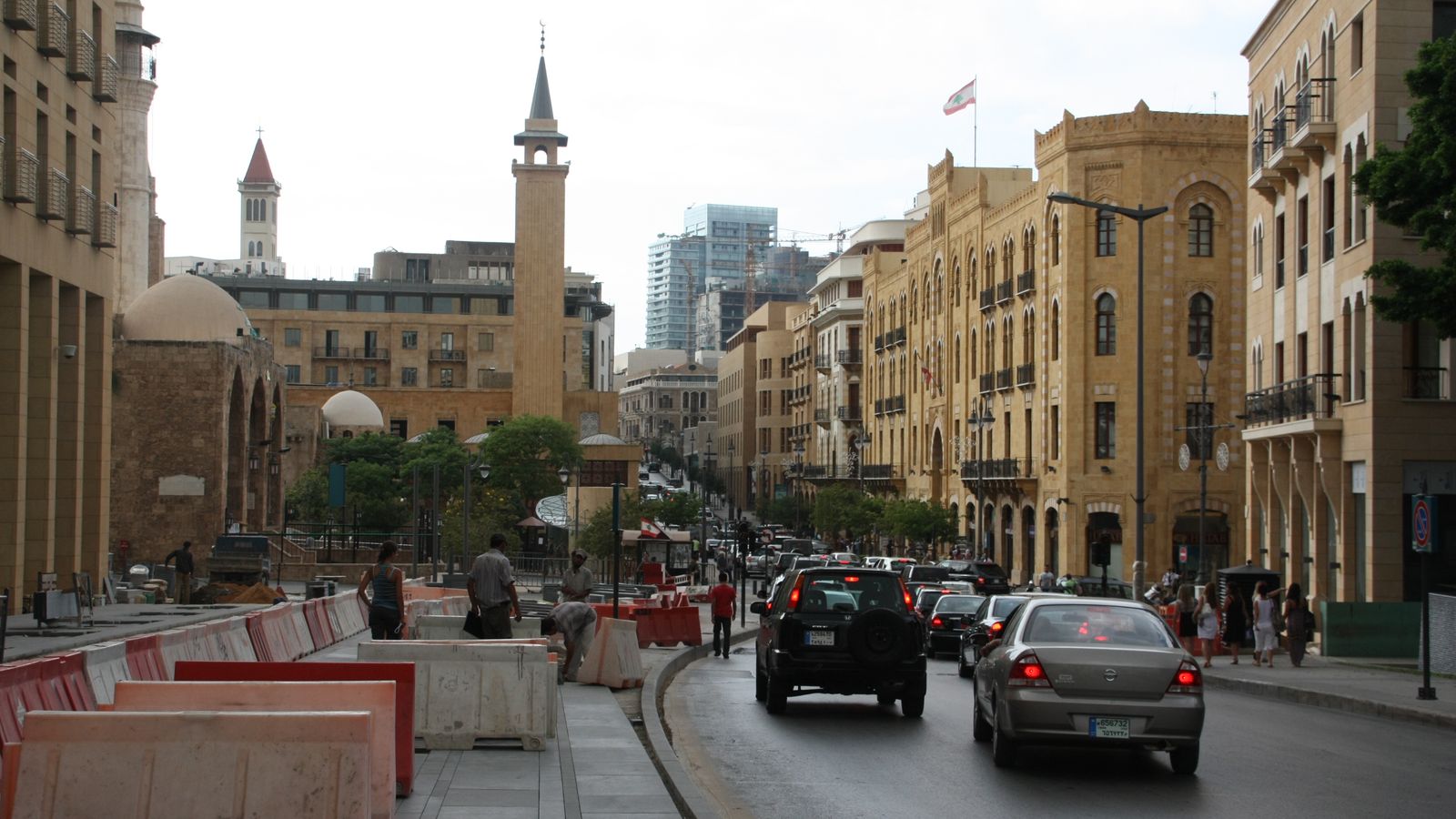 A bustling downtown Beirut street with historic architecture and passing traffic
