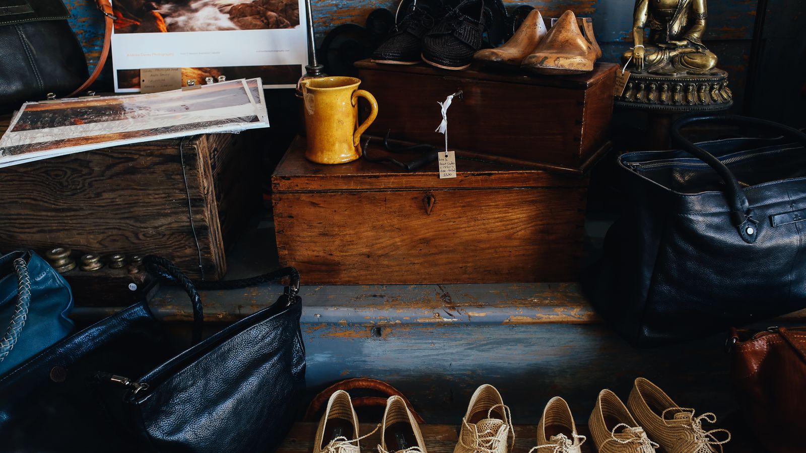 Vintage shoes, handbags and decor arranged on wooden shelves inside a shop