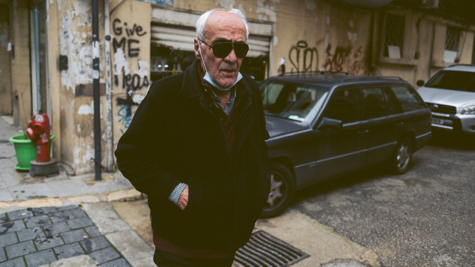 Senior man in sunglasses walking along a sunlit urban street in Beirut