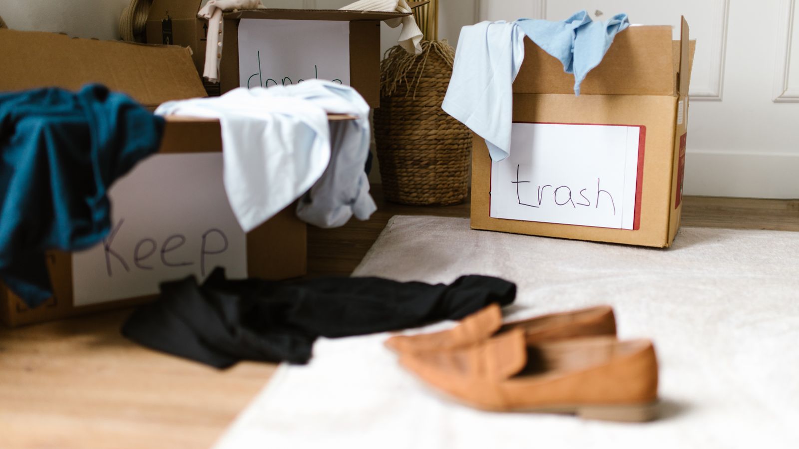 Labeled cardboard boxes used for sorting clothes while decluttering at home