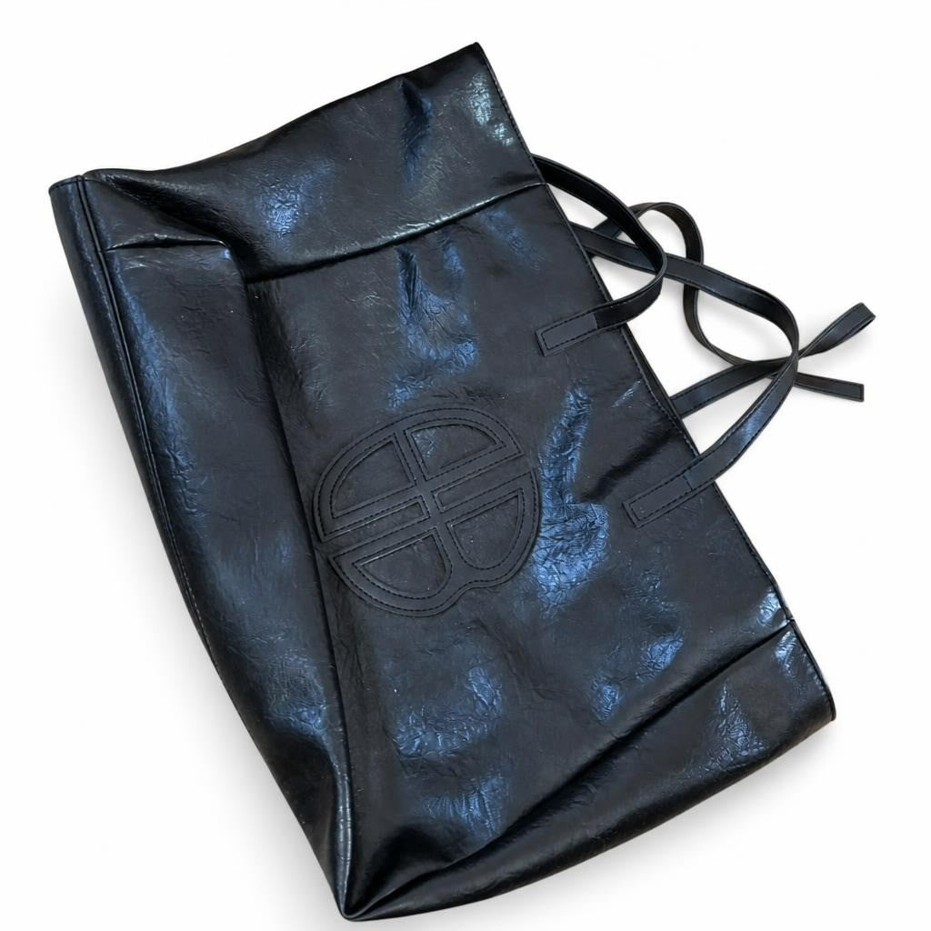 Black faux-leather tote bag, embossed circle logo - white studio shot, second-hand at Why Go Less, Dekwaneh, Lebanon